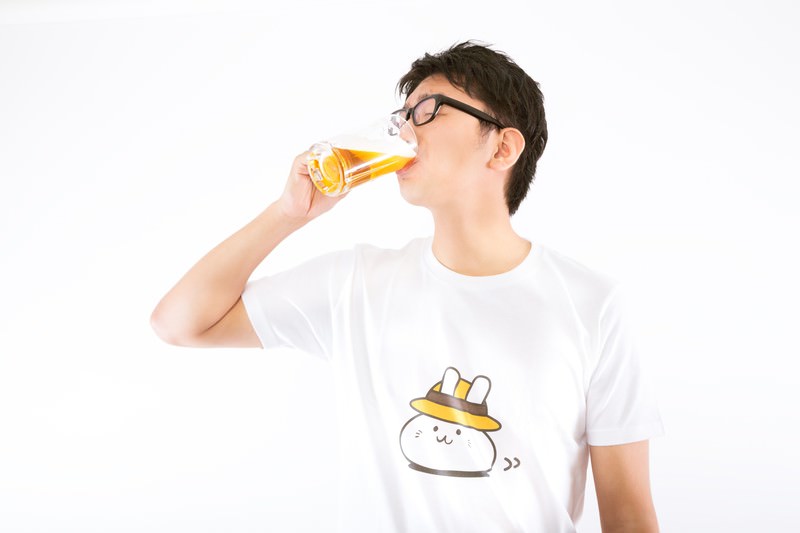 Tシャツ姿でビールを飲む男性