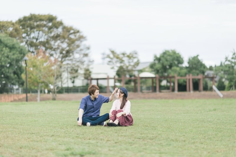 公園の芝生に座っている夫婦